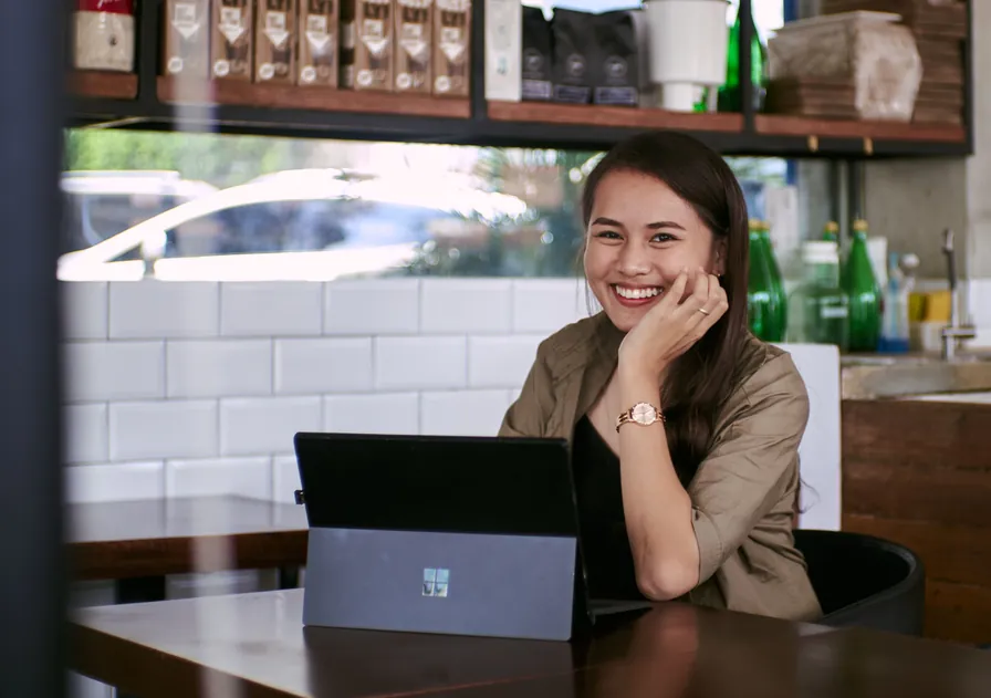 Filipino copywriter working remotely on a laptop in a cafe